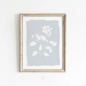Minimalist floral wall art styled in a cozy neutral bedroom with woven textures and natural light