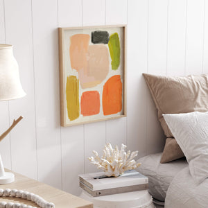 A framed abstract artwork with geometric colour blocks in muted earthy tones, adding a modern touch to a bedroom.