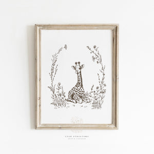 Framed giraffe nursery wall art in sepia tones, styled in a natural, safari-themed kids’ room with neutral and vintage-inspired decor.