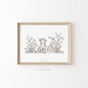 Framed lion cub wall art in soft sepia tones, styled above a nursery dresser for safari-inspired or gender-neutral baby room decor.