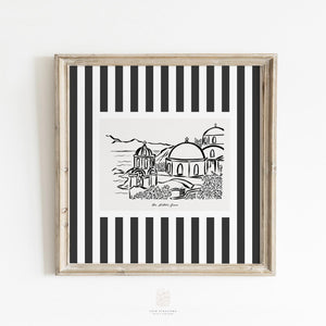 Black and white Santorini sketch print in a rustic frame, styled against a clean white wall - minimalist Greek island wall art for modern decor.