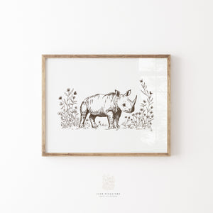 Framed rhino safari animal wall art in natural wood frame, styled for a neutral nursery or baby room with vintage nature-inspired decor.