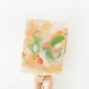 Colorful abstract tulip painting with vibrant orange, green, and yellow brushstrokes, held up in front of a white wall for scale reference.