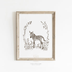 Framed zebra nursery wall art in sepia tones, styled with natural woods and neutral textiles for safari-themed baby room decor.