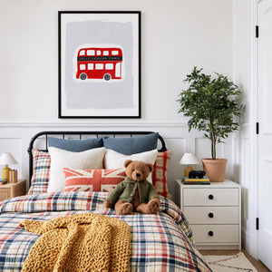 Printable 'Jolly London Town' red double decker bus nursery art, displayed in a mockup over a child's bed with plaid bedding and a Union Jack pillow.