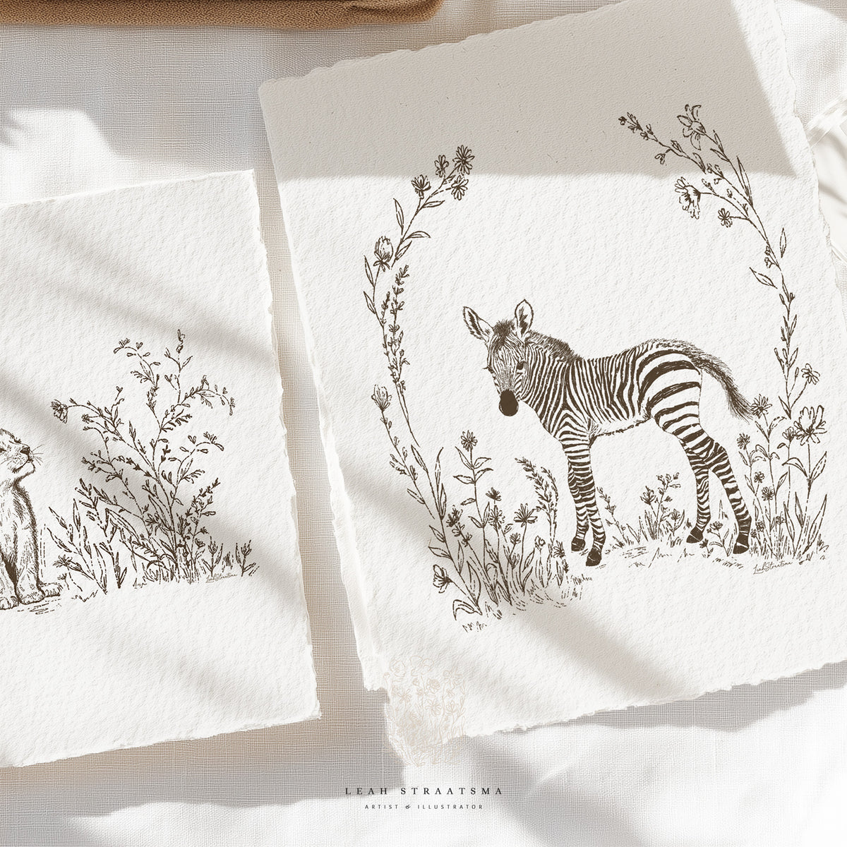 Zebra and lion safari prints displayed on textured paper, perfect for building a cohesive animal-themed nursery wall or safari art collection.