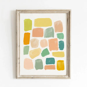 Modern abstract art print with hand-painted color blocks in warm neutrals, golden yellow, and soft green tones. Displayed in a rustic wood frame against a white wall.