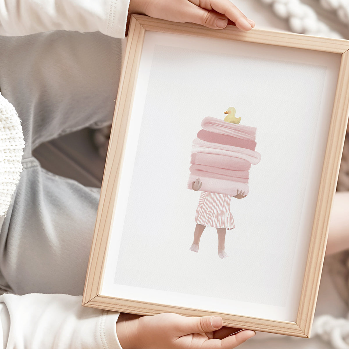 Close-up of girl holding pink towels with duck on top, hand-illustrated with soft shadows on a textured off-white background.