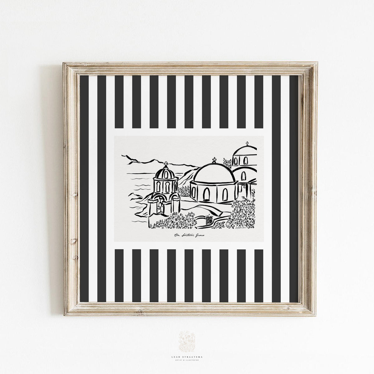 Black and white Santorini sketch print in a rustic frame, styled against a clean white wall - minimalist Greek island wall art for modern decor.