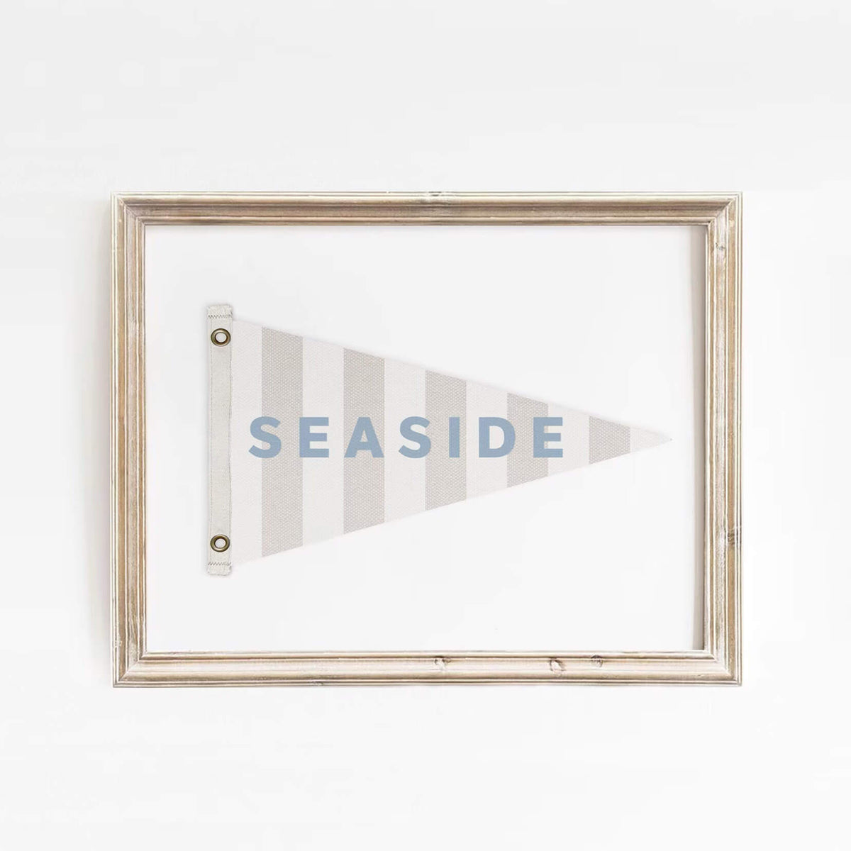 Minimalist Seaside flag art print framed in distressed wood, featuring soft blue text and neutral tones. Ideal for beach house or nautical-themed spaces.