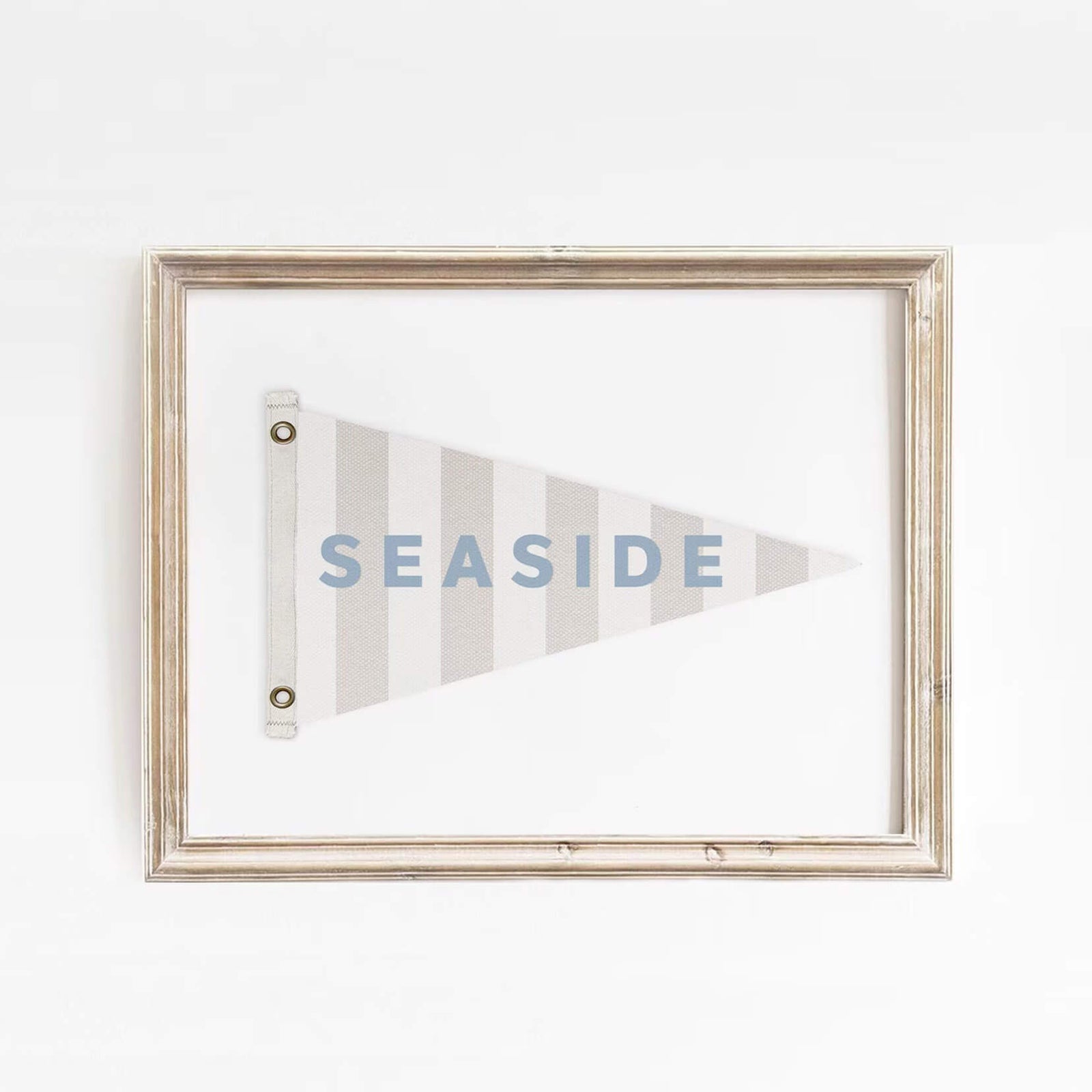 Minimalist Seaside flag art print framed in distressed wood, featuring soft blue text and neutral tones. Ideal for beach house or nautical-themed spaces.