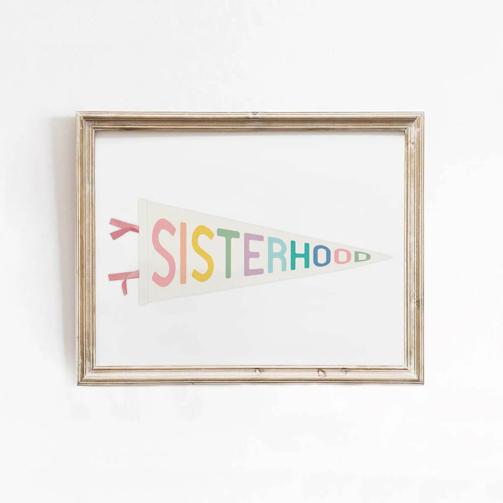 Pennant wall art print with pastel rainbow “SISTERHOOD” lettering, framed for girls room or empowering teen bedroom decor.