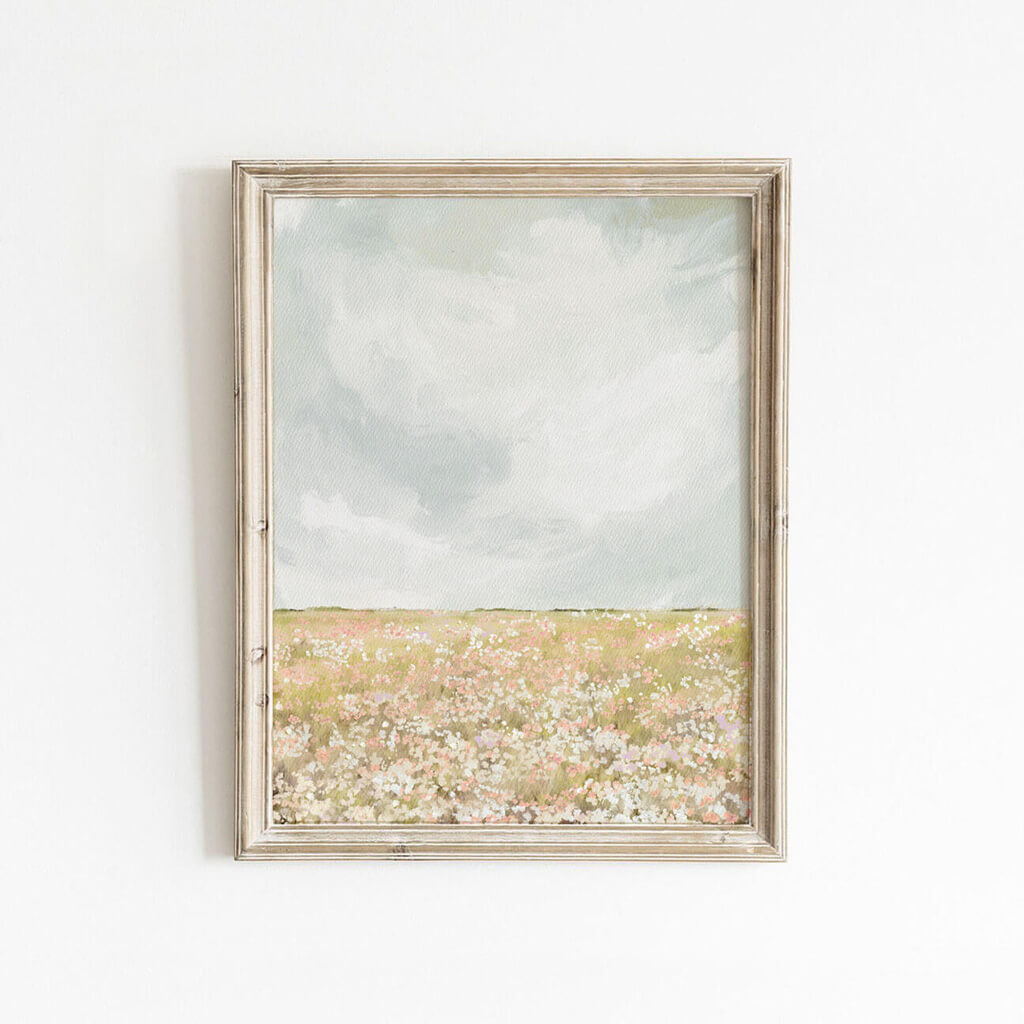 Framed wildflower field art print with soft pastel tones, styled on a white wall for a warm, rustic look