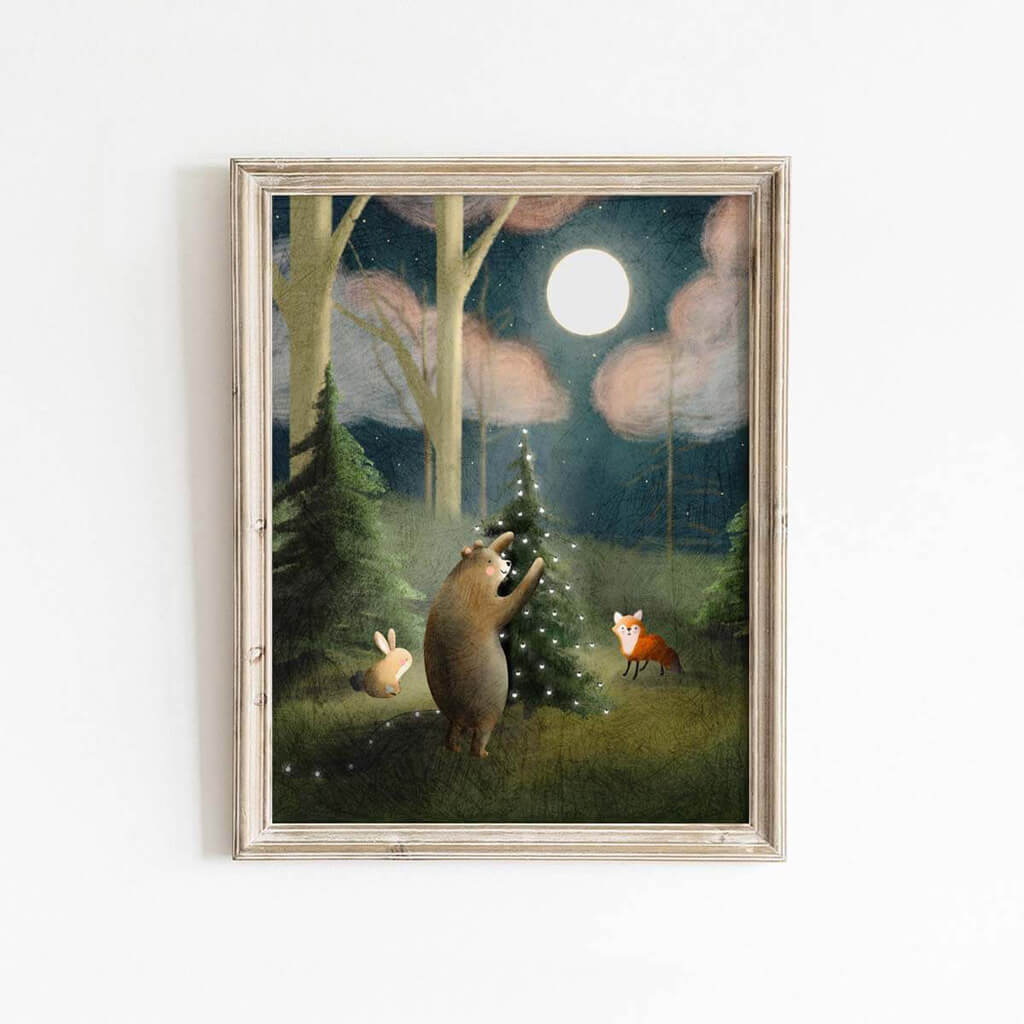 A whimsical Christmas art print of forest animals hanging lights on a Christmas tree by artist Leah Straatsma.