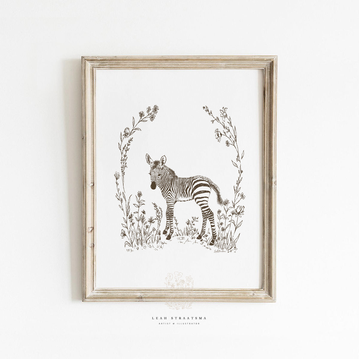 Framed zebra nursery wall art in sepia tones, styled with natural woods and neutral textiles for safari-themed baby room decor.