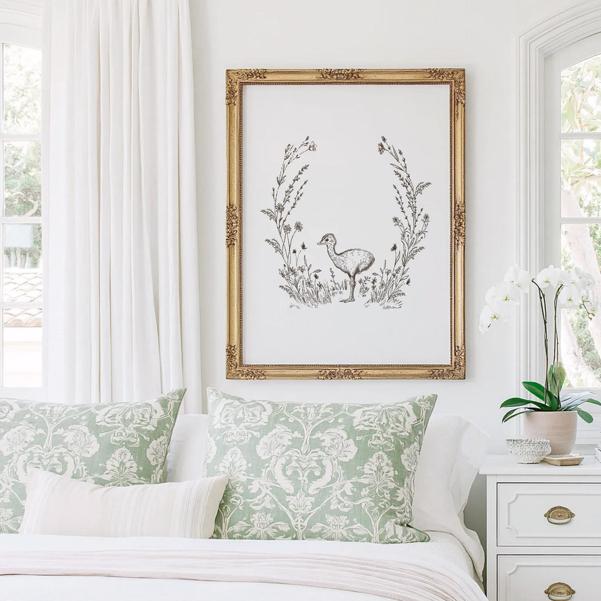 Baby Ostrich Print featuring a hand-drawn ostrich surrounded by delicate wildflowers, displayed in an ornate gold frame above a bed.