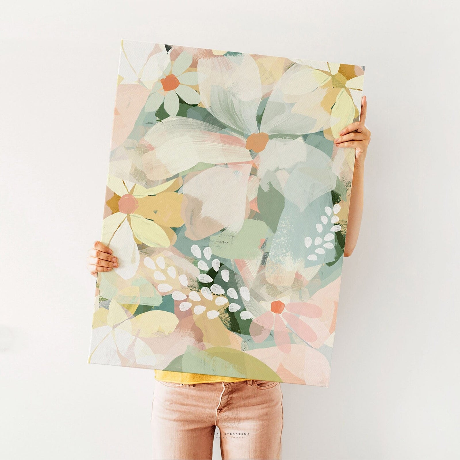 Large pastel daisy print held up against a white wall, showcasing bold brushstroke florals – perfect for modern flower-themed styling.