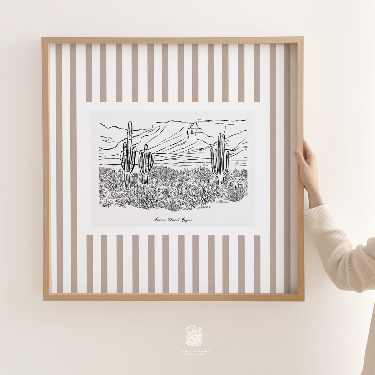 Large striped Sonoran Desert cactus illustration in neutral tones, shown framed in a light wood frame and held up for size reference.